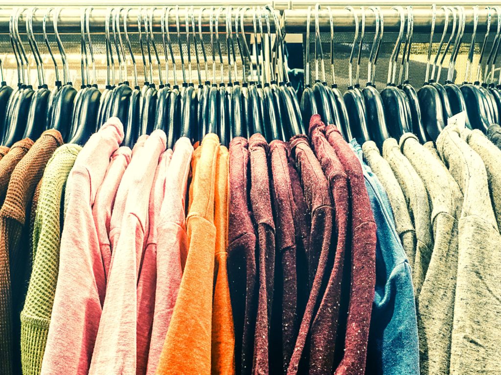 clothes on a rack in a store | places to evangelize